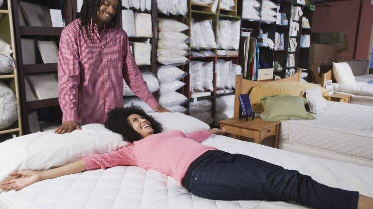 African couple shopping for beds