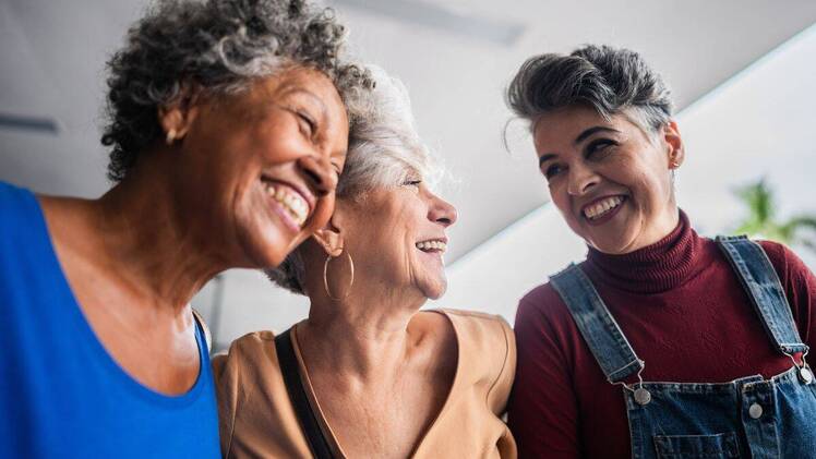 three friends laughing together while celebrating galentines day