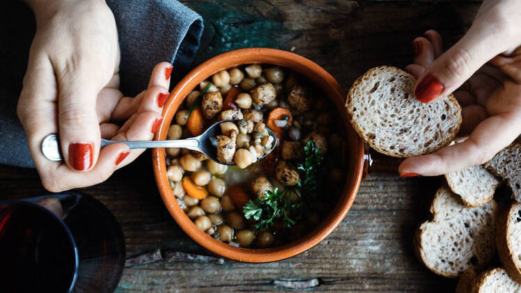 Woman's hands with bowl of bean soup
