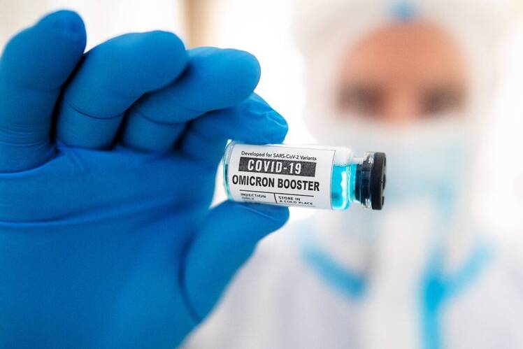 Scientist holding up Omicron vaccine