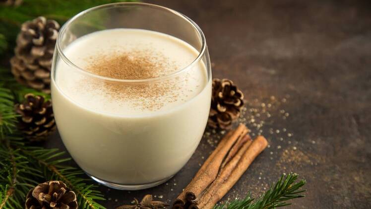 Glass of eggnog with cinnamon sticks