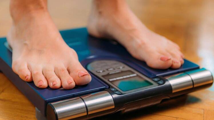 Closeup of woman's feet on digital scale measuring body composition