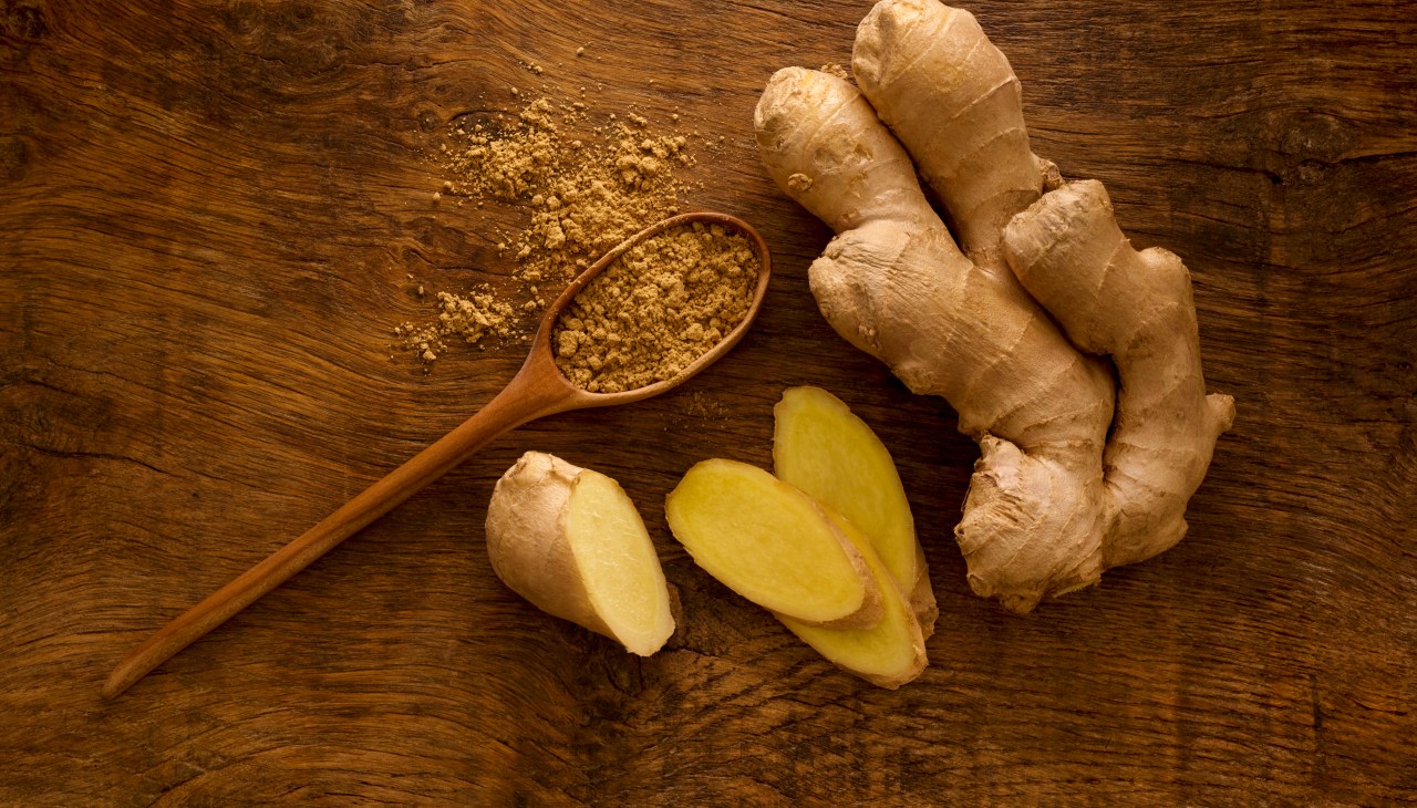 sliced ginger root and ginger powder on table