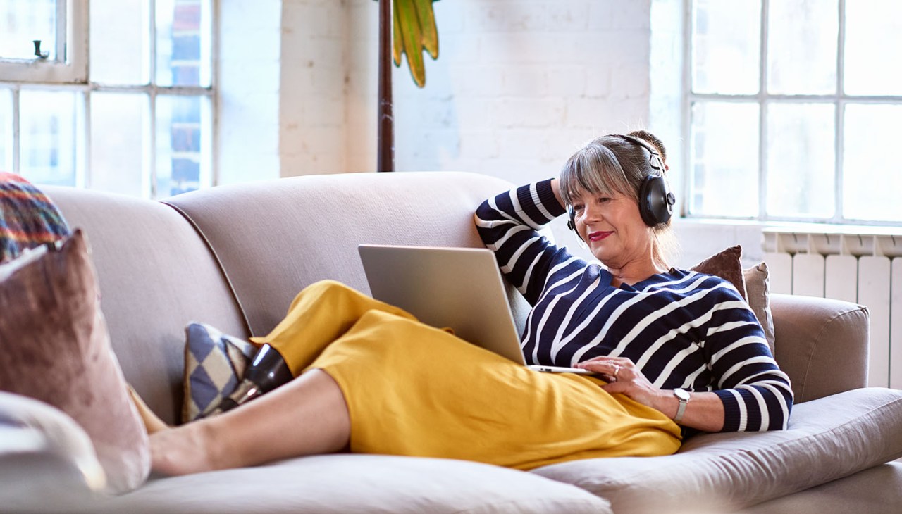 woman listening to headphones looking at computer