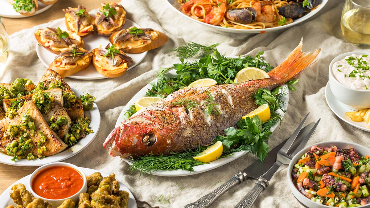 https://www.firstforwomen.com/wp-content/uploads/sites/2/2022/12/Feast-of-Seven-Fishes-on-a-table.jpg