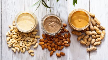 homemade nut butter: nuts with corresponding butters on wooden surface