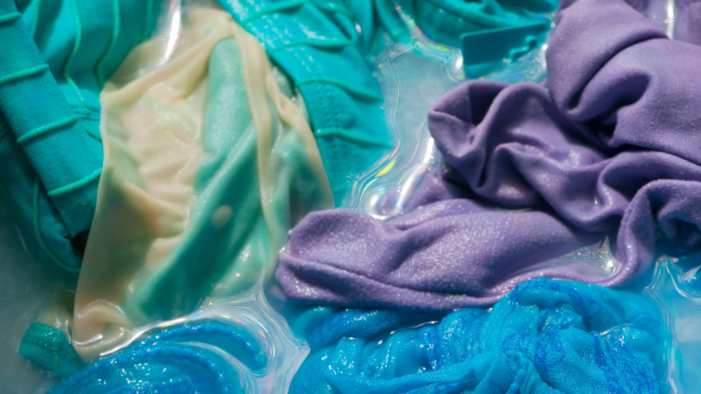 Close-up of blue and purple bathing suits being washed 