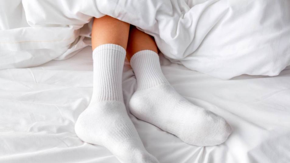 Pair of white socks in white bed