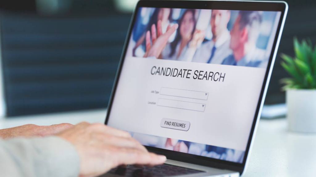 Businessman looking at recruitment website on a laptop computer. Candidate search page with job type and location buttons