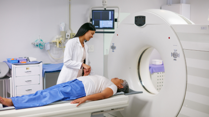 Mature woman next to a doctor preparing for a virtual colonoscopy CT scan