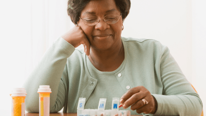 Black woman taking pills, which is one option for administering bioidentical hormone replacement therapy