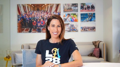 Former Olympian Janet Evans smiles, wearing an LA28 shirt for the next Olympic Games