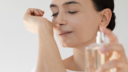 Woman applying one of the best summer perfumes