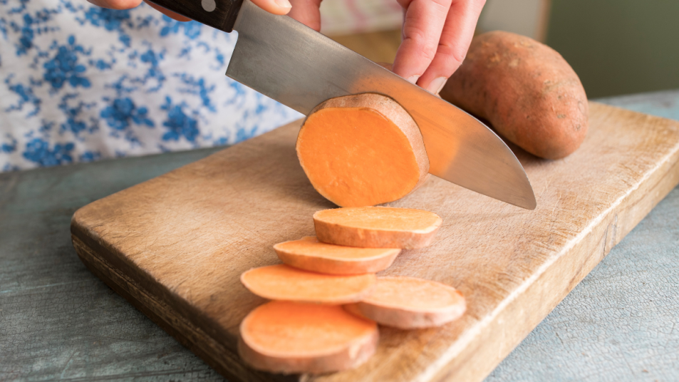 Woman cutting sweet potatoes, which are part of the slow-carb diet food list