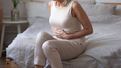 woman holding stomach in pain; Gut-stress connection