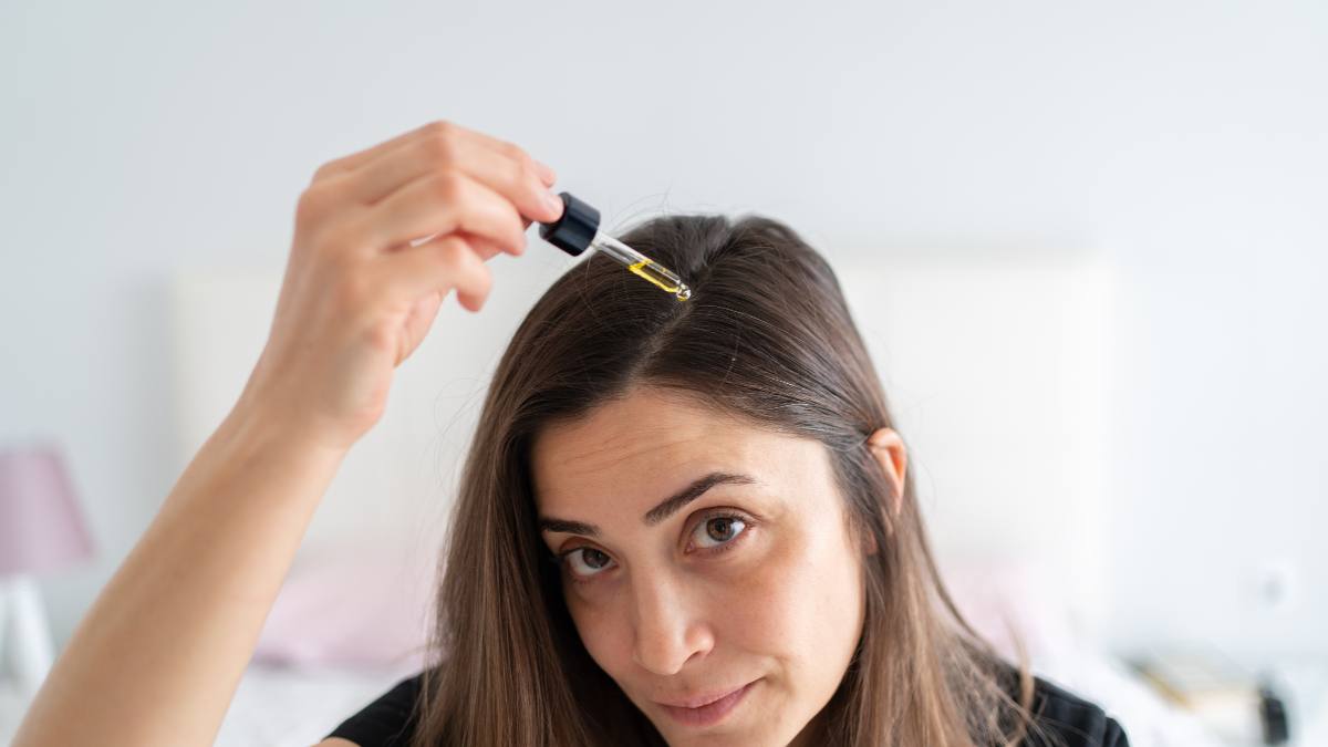 Woman puts serum in her hair