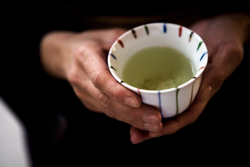 woman holding a cup with green tea, which is one of the best natural alternatives to Ozempic