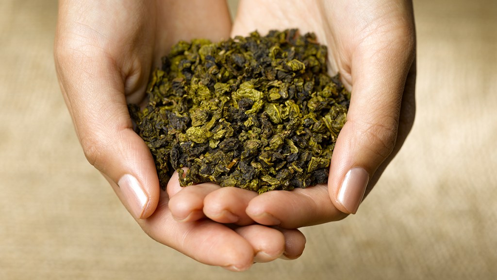 closeup of woman holding green tea leaves; coffee loophole
