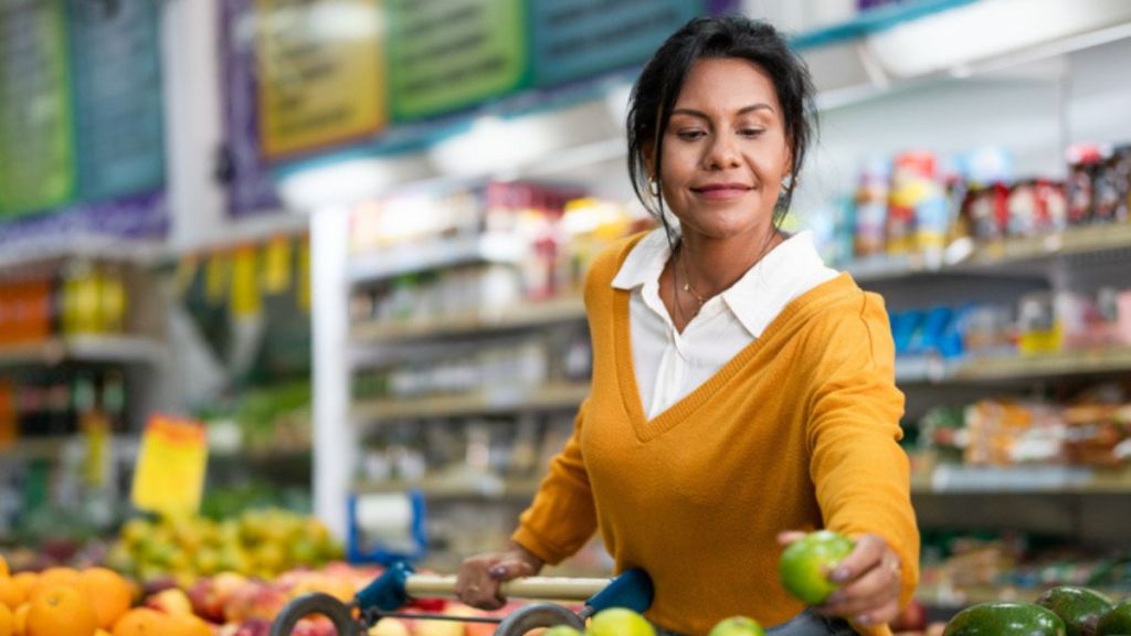 mature woman picking out produce at the grocery store